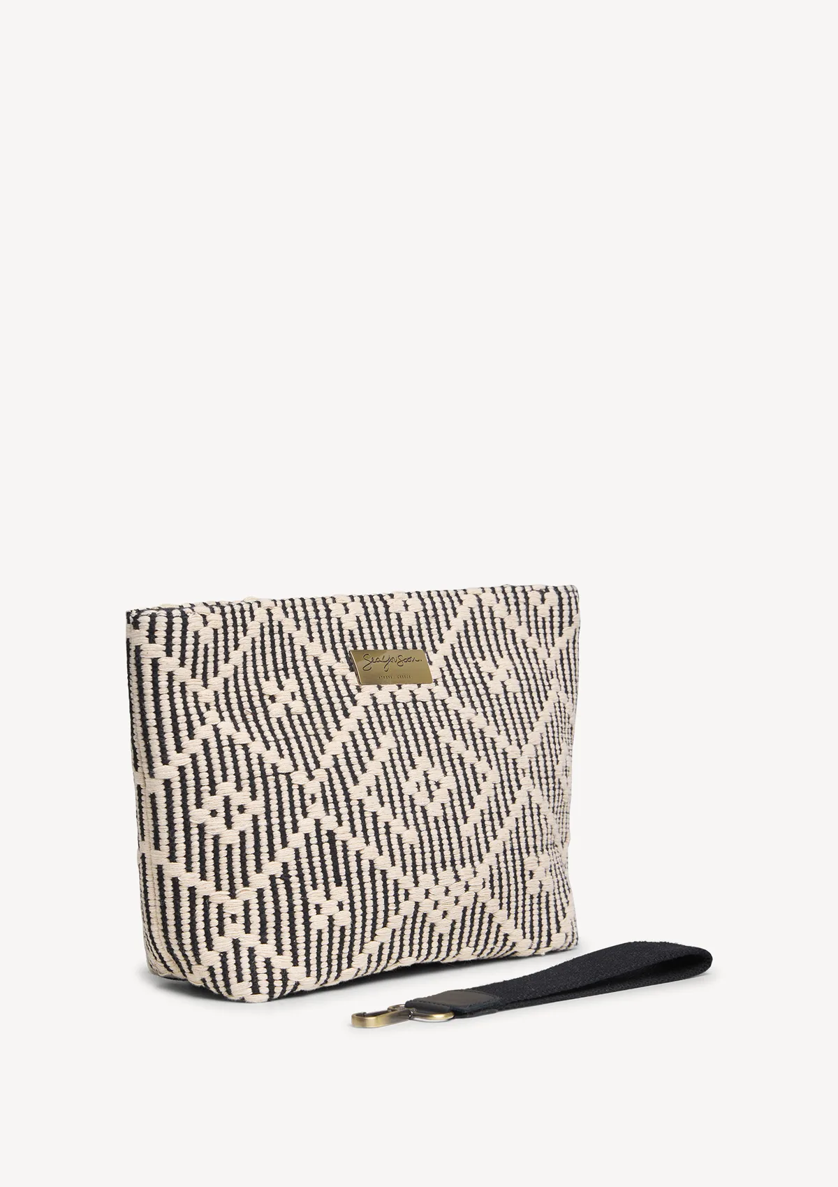 duomo-cotton-midi-clutch-black-lifestyle-side Sea You Soon Ballos Mini Clutch in black, angled view highlighting the weave and shape